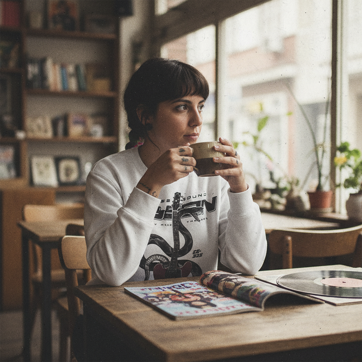 Mujer en cafetería usando el Poleron Gibson ES-335 exclusivo Ritmoculto