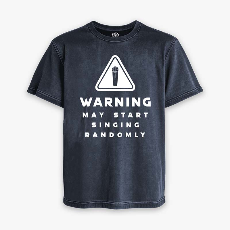 Polera Acid de color azul oscuro gastado. Diseño frontal con icono de advertencia y el texto en inglés "WARNING MAY START SINGING RANDOMLY"