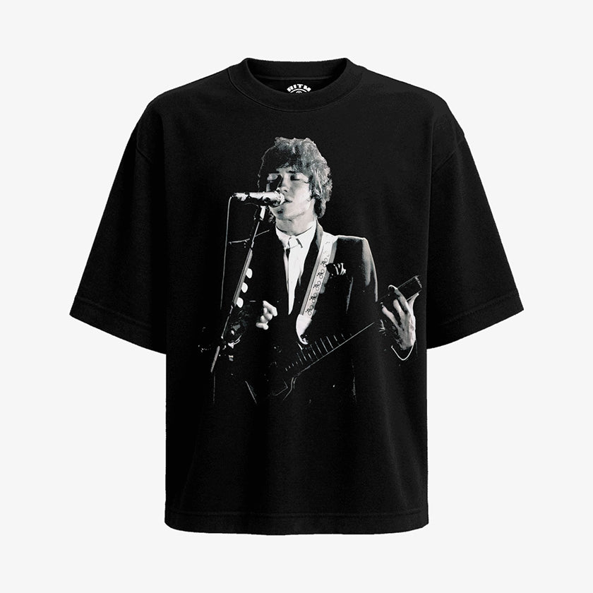 Polera Negra Oversized Andrew VanWyngarden MGMT Tocando Guitarra en estilo brutalismo exclusivo de Ritmoculto