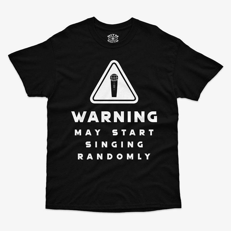 Polera de color negro. Diseño frontal con un icono de advertencia y el texto en inglés "WARNING MAY START SINGING RANDOMLY"