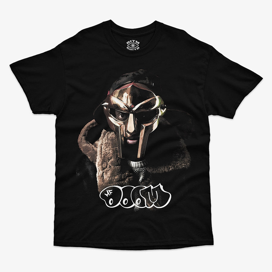 Polera negra clásica foto MF DOOM con máscara plateada y abrigo de piel café texto graffiti blanco hip hop underground Ritmoculto