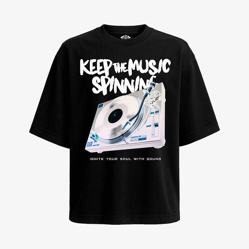 Polera negra oversized con diseño de tornamesa, texto "KEEP THE MUSIC SPINNING" y "IGNITE YOUR SOUL WITH SOUND"