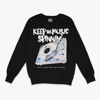 Polerón negro cuello redondo con diseño de tornamesa, texto "KEEP THE MUSIC SPINNING" y "IGNITE YOUR SOUL WITH SOUND"