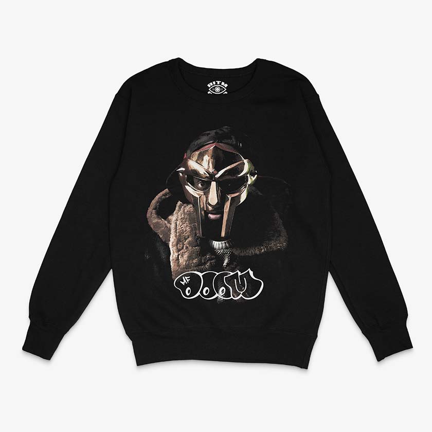 Polerón negro oversized cuello redondo foto MF DOOM con máscara plateada y abrigo de piel texto graffiti blanco hip hop underground Ritmoculto